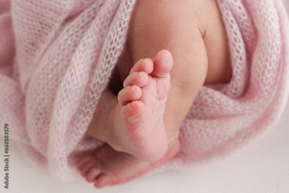 Close-up of tiny, cute, bare toes, heels and feet of a newborn girl, boy. Baby foot on pink soft coverlet, blanket. Detail of a newborn baby legs. Macro horizontal professional studio photo. Close-up of tiny, cute, bare toes, heels and feet of a newborn girl, boy. Baby foot on pink soft coverlet, blanket. Detail of a newborn baby legs. Macro horizontal professional studio photo.