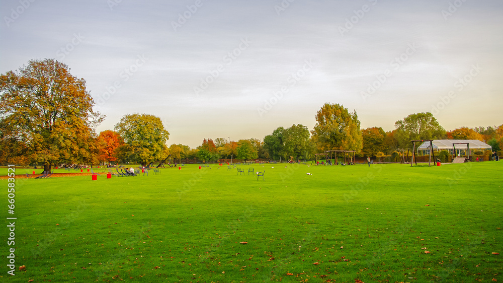 Mannheim, Germany. Playground for children and families. Panoramic view over Luisen city park at sunset golden Autumn colors. Cityscape in the historical downtown at sunny day and milky blue sky.
