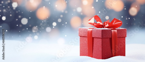 A Christmas winter and new year background - gift box with red bow on blue defocused on the forest background of dreamy blurred bokeh effect, creating a magical and festive atmosphere. Generative ai © Mickael