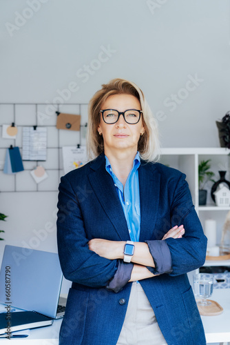 Portrait of 50's stylish, confident mature businesswoman, middle age company ceo director, experienced senior female professional, business coach team leader in modern office. Female leader. Vertical. photo