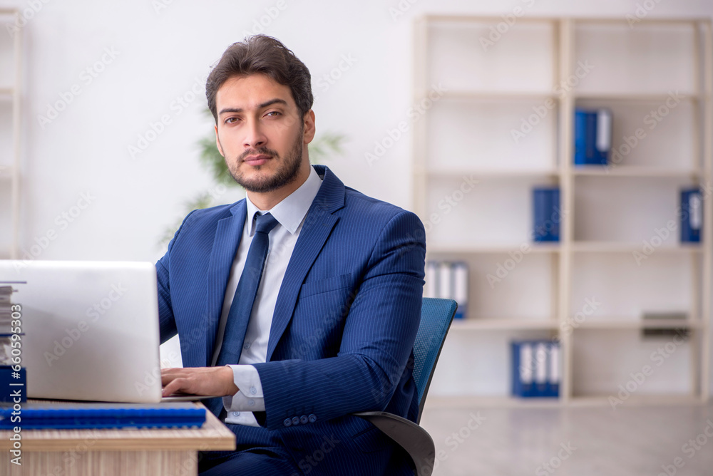 Young male employee working in the office Young male employee working in the office