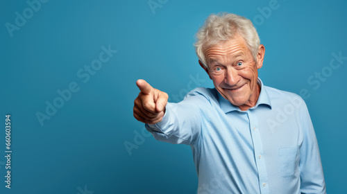 Senior man pointing with hand and finger to the side looking at the camera.