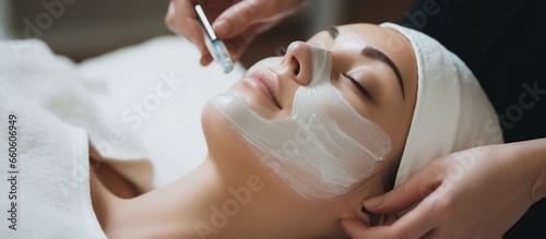 young woman having facial mask spa therapy in beauty salon photo
