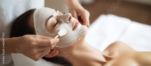 young woman having facial mask spa therapy in beauty salon photo
