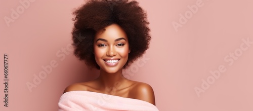 Beauty portrait of African American woman with clean and healthy skin on pink background. Beautiful smiling girl with curly black hair