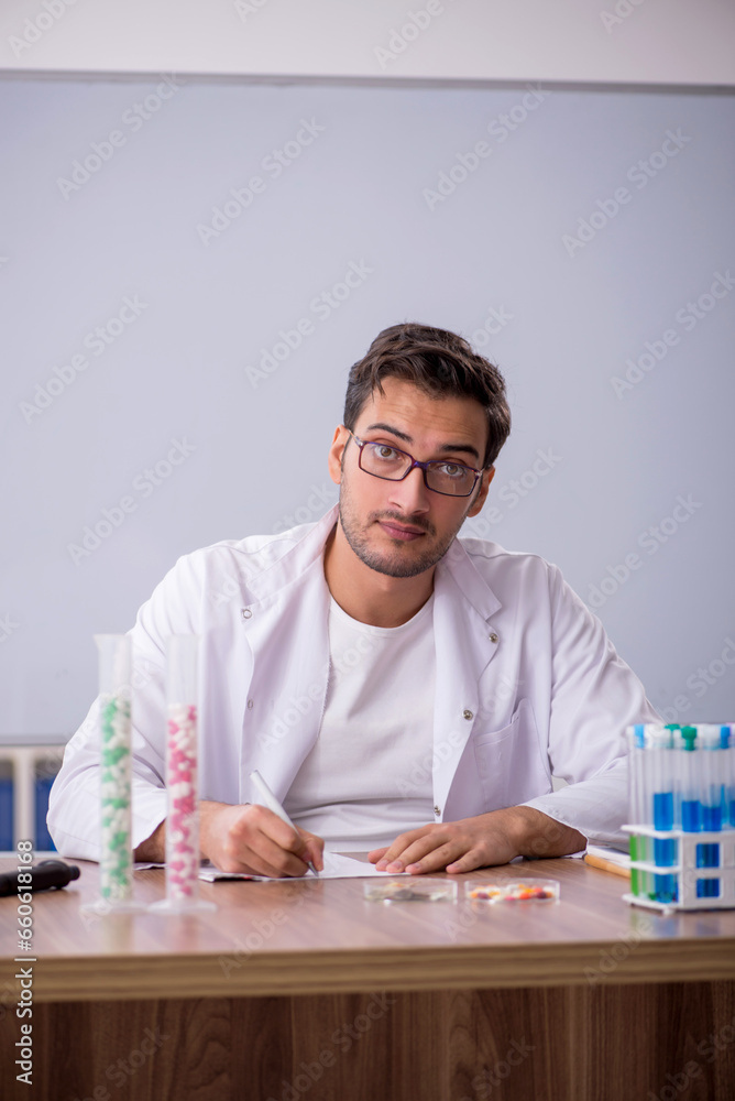 Young male chemist in front of white board Young male chemist in front of white board