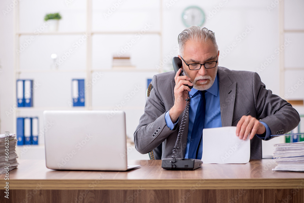 Old male employee working in the office Old male employee working in the office