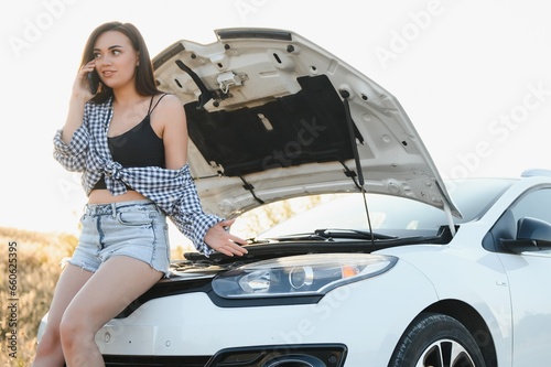 Young sexy woman with broken car calling on the cell phone. © Serhii