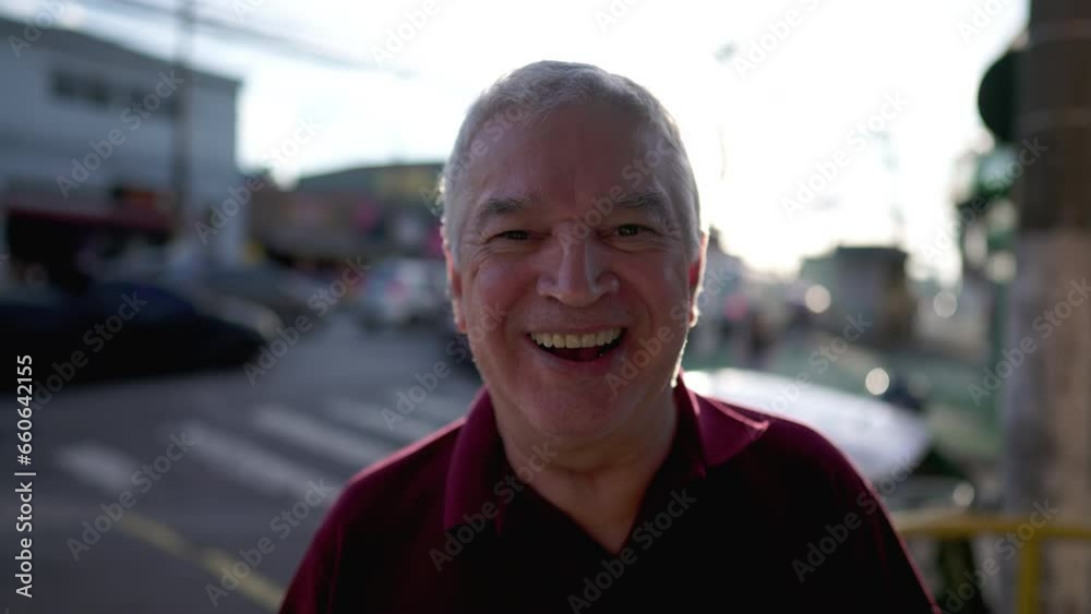Joyful Senior Man Smiling at Camera in Urban City, Sunlight Flare Background Joyful Senior Man Smiling at Camera in Urban City, Sunlight Flare Background