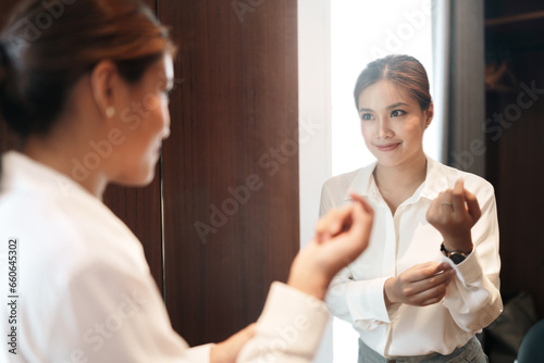 Young woman getting dress in front of mirror to preparing ready for interview and recruitment work