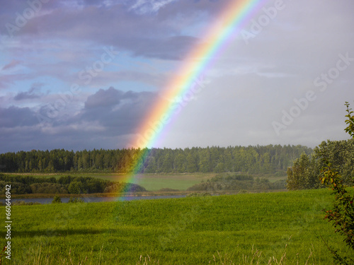 Scenic view of rainbow over field against sky