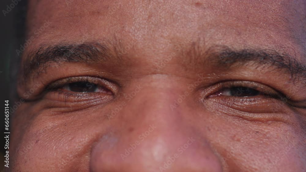 Macro close-up of a happy black man eyes smiling. extreme detail of a joyful African American person in 30s Macro close-up of a happy black man eyes smiling. extreme detail of a joyful African American person in 30s