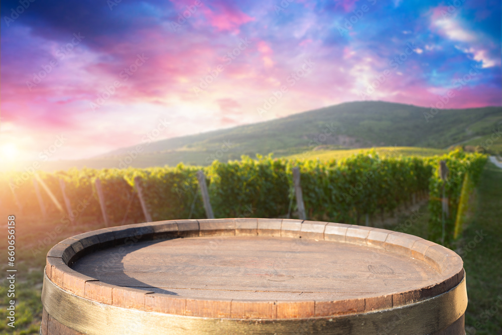Red wine bottle and wine glass on wodden barrel. Beautiful Tuscany background. High quality photo
