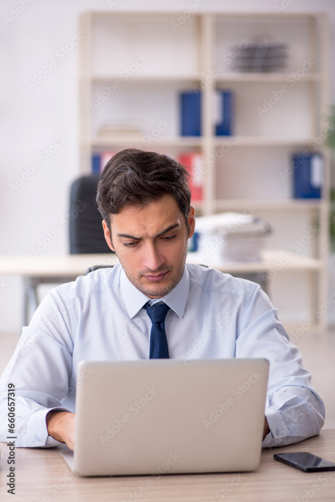 Young male employee working in the office Young male employee working in the office