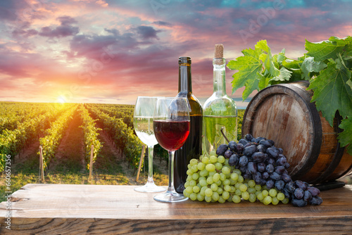 Fototapeta Naklejka Na Ścianę i Meble -  Red wine bottle and wine glass on wodden barrel. Beautiful Tuscany background. High quality photo
