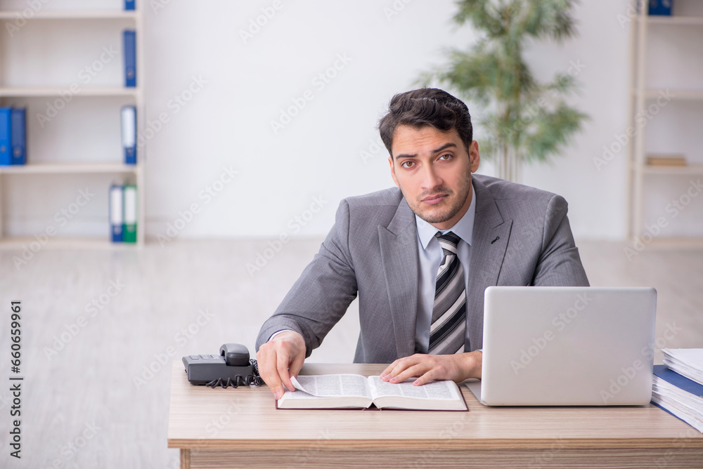 Young male employee working in the office Young male employee working in the office