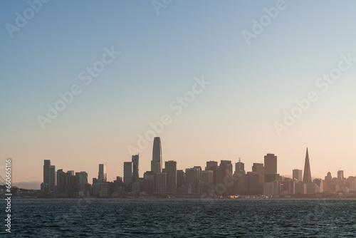 A picturesque skyline of San Francisco Panorama at sunset golden hour from Treasure Island  California  United States. Panoramic view of cityscape with mist and foggy air. Illuminated dusk city