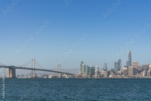 A picturesque skyline of San Francisco Panorama at sunrise from Treasure Island, California, United States. Panoramic view of cityscape with mist and foggy air at morning day time.