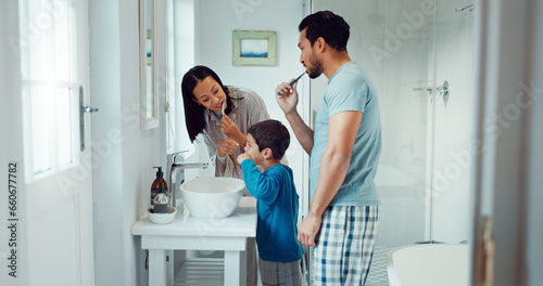 Parents  child and brushing teeth in family home bathroom while learning or teaching dental hygiene. A woman  man and kid with toothbrush and toothpaste for health  cleaning mouth and wellness