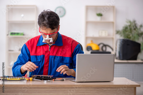 Young male repairman repairing computer