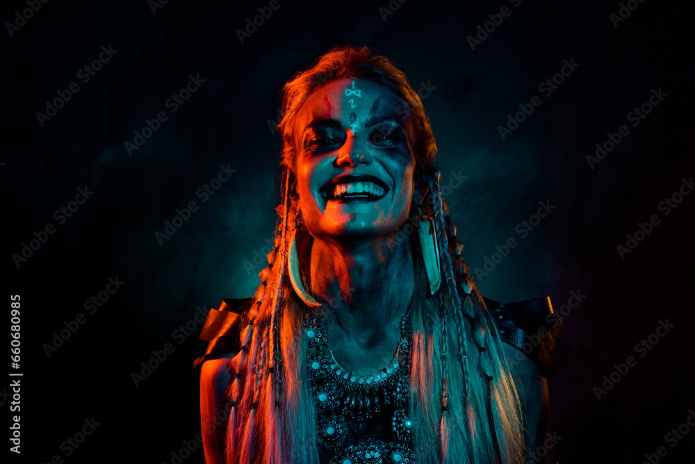 Photo of angry crazy mysterious lady wear viking clothes laughing isolated dark orange smoke background