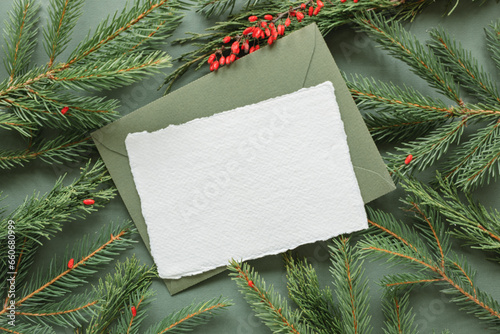 Overhead view of a blank card and envelope on fir branches and berries photo