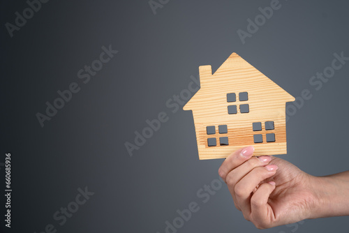 Woman holding a model of a house in her hand