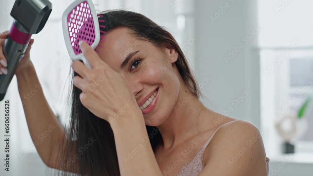 Brunette lady arranging hair smiling at bath portrait. Happy girl posing camera