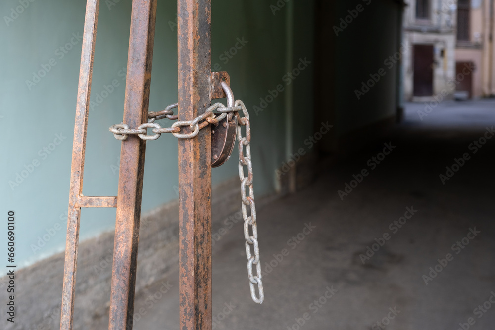 Padlock and chain on a metal gate in the arch of a house Padlock and chain on a metal gate in the arch of a house