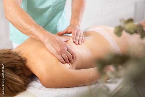 the client lies on his stomach while the worker gives a massage