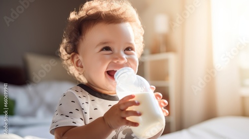 Adorable Smiling Baby Holds Milk Feeding Bottle - Joyful Infant Enjoying Milk Formula for Babies photo