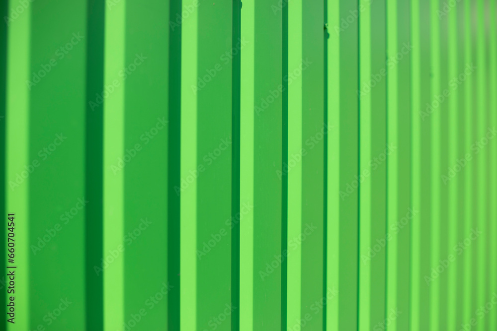 Green fence. Ribbed metal. Light green background.