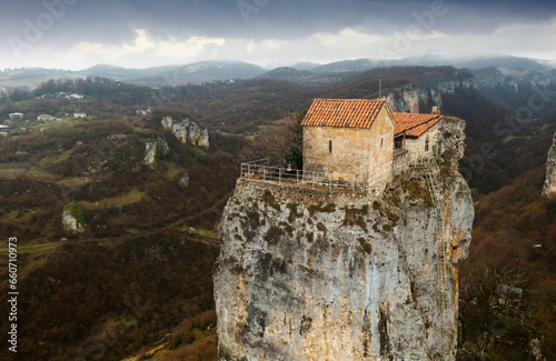 Tourist Georgia. Famous Katskhi pillar near town of Chiatura in Imereti with small monastery and Church of Maxim Confessor on top. Aerial view on cloudy spring day. photo