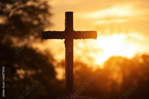 Concept photo of a Cemetery Cross, captured in the golden light of sunset. The cross seems to glow against the warm colors of the sky, representing the light and hope that faith can bring