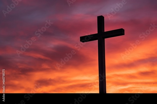 Closeup of a wooden cross, silhouetted against a vibrant orange and pink sky, symbolizing the sacrifice of Jesus and the hope of new life in his resurrection.