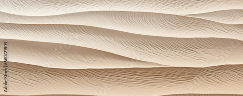 Sunbleached rippled sand on a shoreline, with a muted, dusty hue and distinctive patterns created by the tide.