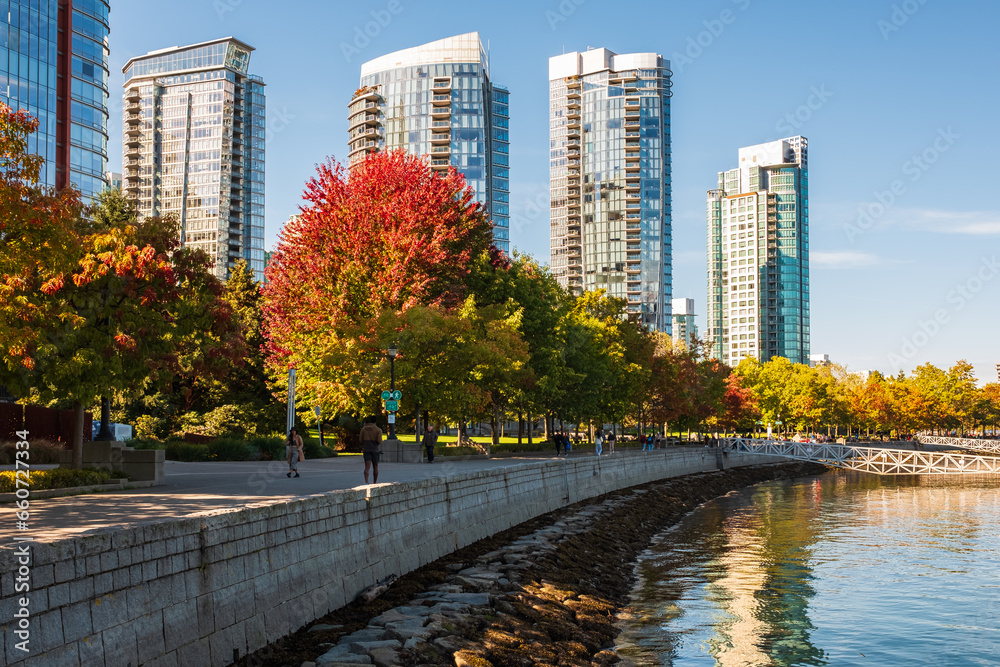 Naklejka premium Downtown Vancouver modern Coal Harbor business district area high office and apartment buildings. Autumn Colors alone the Sea Walk in Stanley Park Vancouver BC Canada. Travel photo, street view