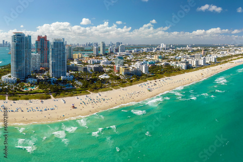 Aerial view of South Beach sandy surface with tourists relaxing on hot Florida sun. Miami Beach city with high luxury hotels and condos. Tourism infrastructure in southern USA #660728158