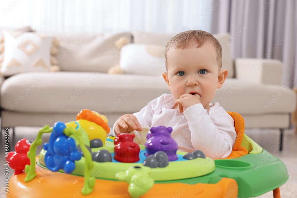 Portrait of cute baby with toy walker at home. Learning to walk Portrait of cute baby with toy walker at home. Learning to walk