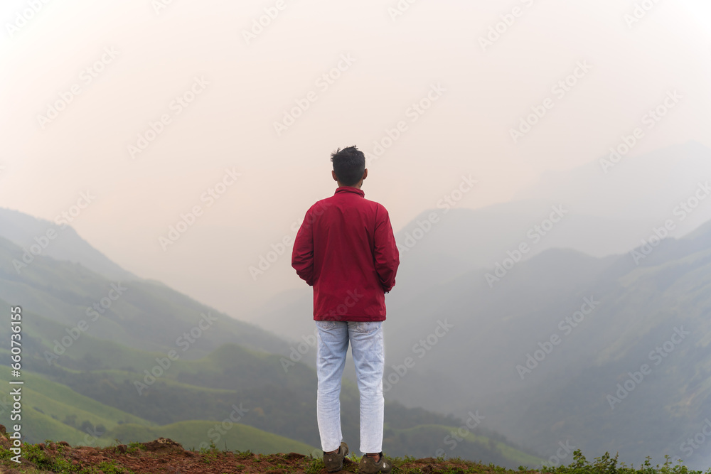 happy Young unknown man standing in front of mountain landscape 