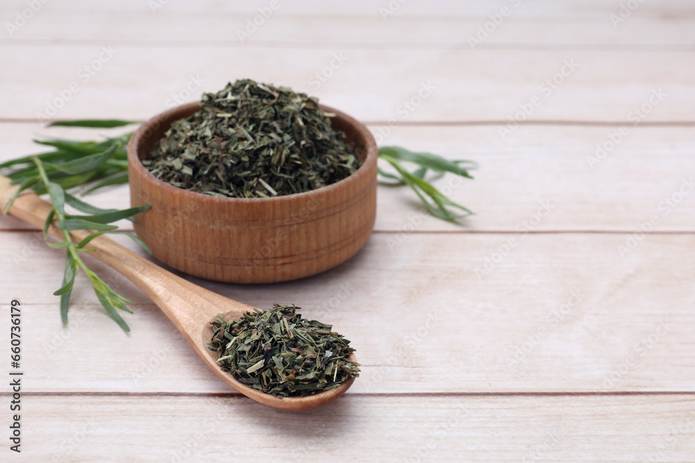 Dry and fresh tarragon on wooden table, space for text Dry and fresh tarragon on wooden table, space for text