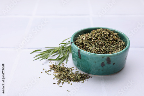 Dry and fresh tarragon on white tiled table, space for text