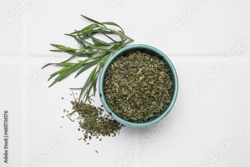 Dry and fresh tarragon on white tiled table  flat lay