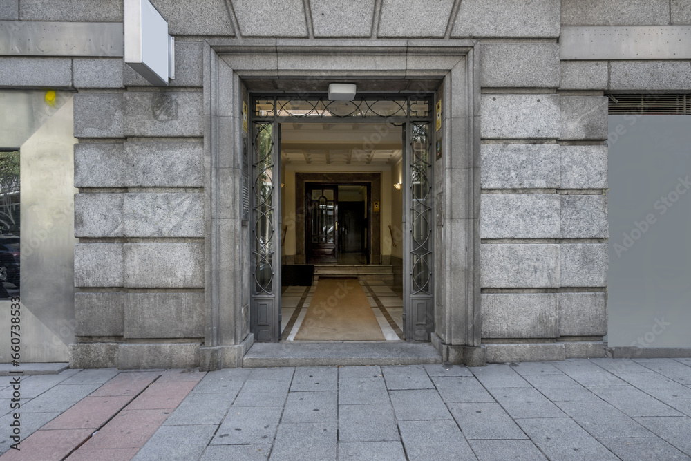 Access portal to a vintage building with a façade of granite blocks and street floors of the same material