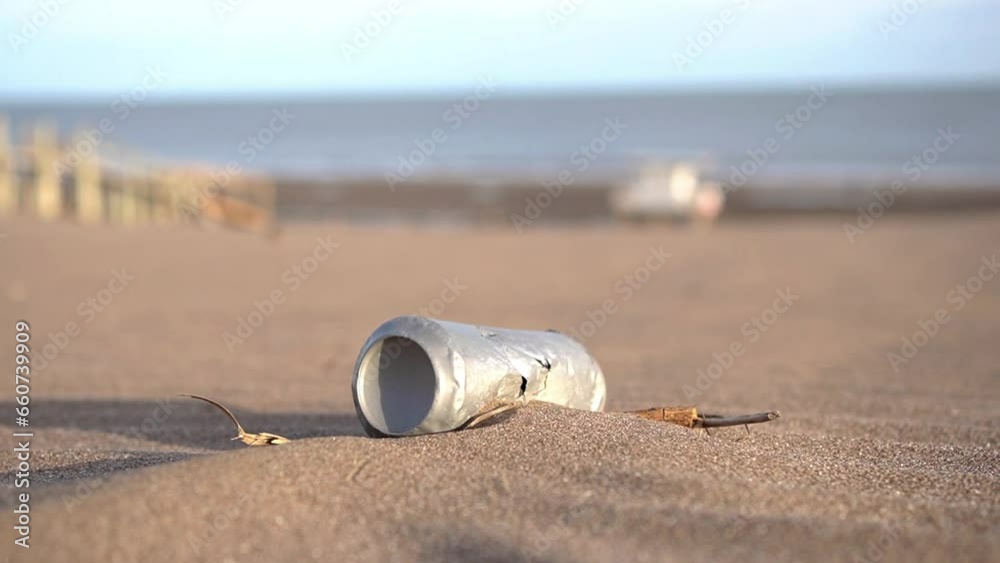 Deteriorated and oxidized aluminum can dumped on a beach polluting the coastal marine environment.