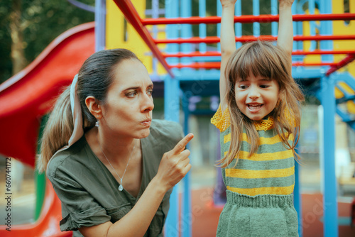 Foto Mom Forbidding her Child to Climb on a Dangerous Playground Equipment