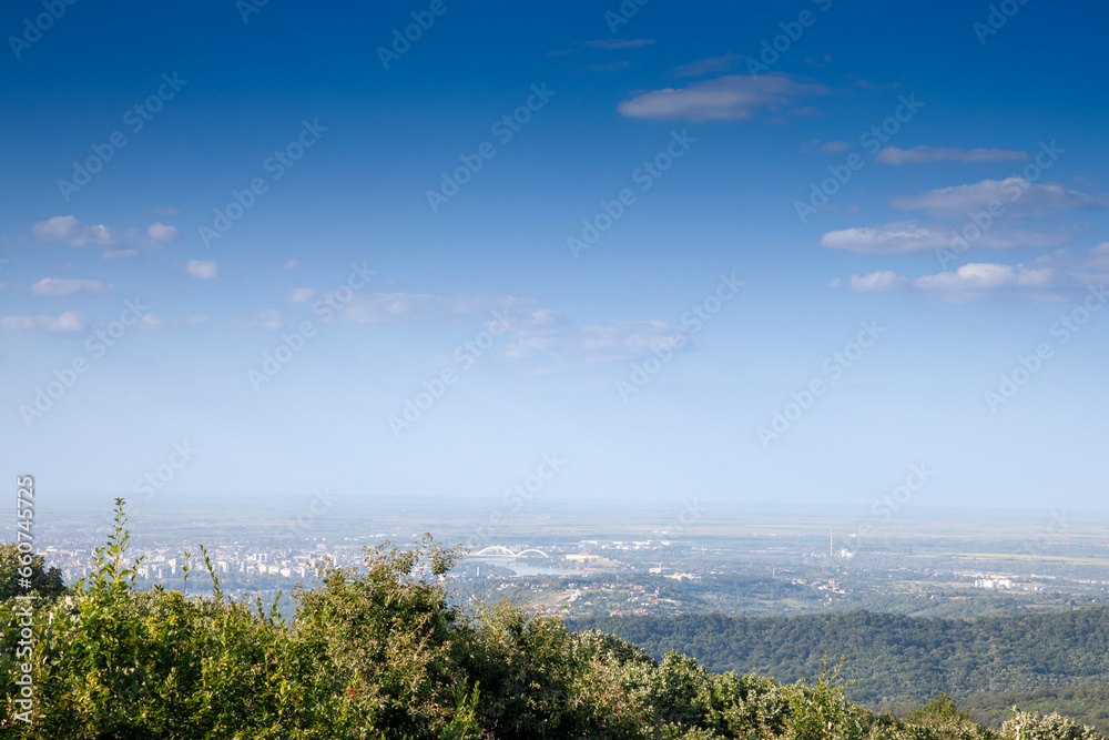 Aerial panoramal of Novi Sad, seen from a hill of Fruska Gora National park during a summer afternoon. Novi Sad is the capital city of Vojvodina and a major place in Serbia. Aerial panoramal of Novi Sad, seen from a hill of Fruska Gora National park during a summer afternoon. Novi Sad is the capital city of Vojvodina and a major place in Serbia.