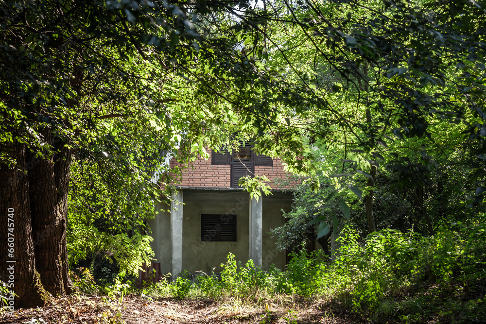 Selective blur on an old Residential house, a chalet building, called vikendica, closed and abandoned, in decay, overgrown by vegetation in the Balkans in Devojacki Bunar. Selective blur on an old Residential house, a chalet building, called vikendica, closed and abandoned, in decay, overgrown by vegetation in the Balkans in Devojacki Bunar.