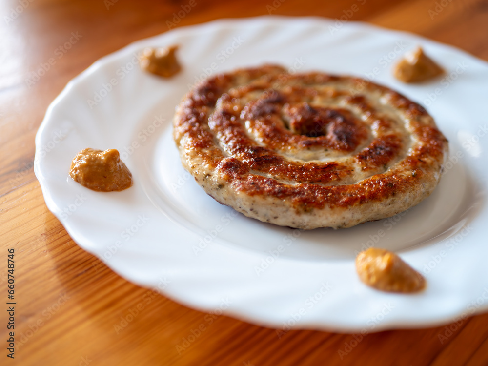 Traditional German Delicious Bratwurst Snail with Bavarian Mustard on a White Plate