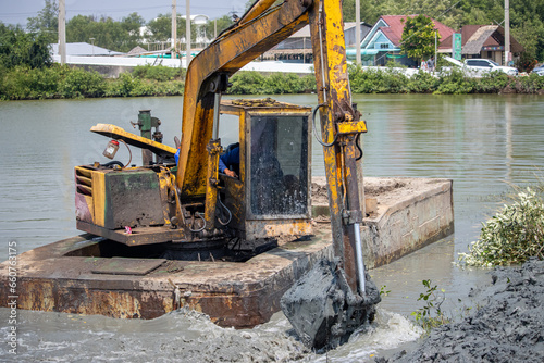 A floating dredger is dredging the bottom of the pond, Thailand photo